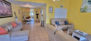 a living room with couches and a dining room at 3 bedr w-private pool 1 block to beach Pets Ok in South Padre Island