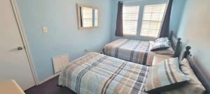 a bedroom with two beds and two windows at 3 bedr w-private pool 1 block to beach Pets Ok in South Padre Island