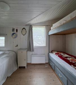 Un dormitorio pequeño con una litera y una ventana. en Holiday Home Overlooking Fishing Harbour In Hvaler, en Spjær