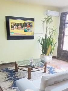 a living room with a glass coffee table and a tv at Hotel Diplomata in Tupanciretã