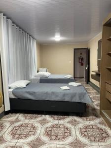 a hotel room with two beds in a room at Hotel Diplomata in Tupanciretã