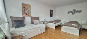 een witte kamer met twee bedden en een spiegel bij Casaba Suite 2-150qm-4 Rooms-Free Private Parking-House with garden in Hannover +7 foto's