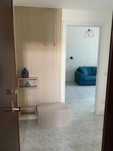 a living room with a blue couch and a stool at Pitia House in Rozzano