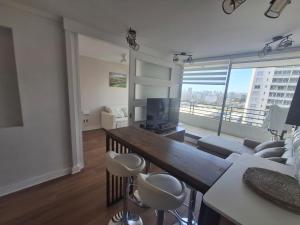 a living room with a couch and a table with chairs at Departamento centro Viña del Mar in Viña del Mar