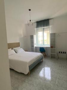 a bedroom with a large white bed and a window at Pitia House in Rozzano