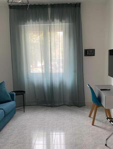 a living room with a blue couch and a window at Pitia House in Rozzano