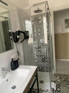 a bathroom with a shower with a sink and a mirror at Pitia House in Rozzano