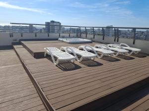a group of white chairs sitting on a deck at Departamento centro Viña del Mar in Viña del Mar