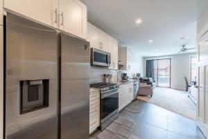 a kitchen with a refrigerator and a stove top oven at Stylish Grand Lake Retreat - King Bed - Walk to Lake in Grand Lake