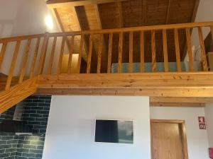 a wooden staircase in a living room with a stair case at Vila Lira in Aljezur