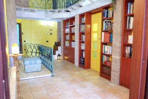 a hallway with bookshelves and a staircase in a library at B&B Sa Sinniesa in Sìnnai