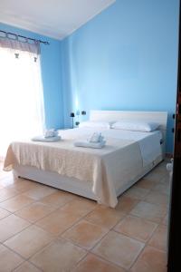 a bedroom with a large bed with a blue wall at B&B Sa Sinniesa in Sìnnai