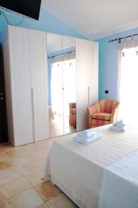 a bedroom with a white bed and a mirror at B&B Sa Sinniesa in Sìnnai