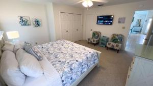 une chambre avec un lit et deux chaises dans l'établissement Upscale & Spacious Home Renovated Pool, à South Padre Island