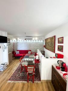a living room with a table and a red couch at Ca' Sole in Butera