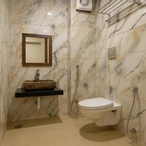 a bathroom with a toilet and a sink and a mirror at Mangal Residency Rooftop Pool in Udaipur