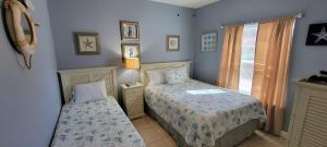 a bedroom with two beds and a window at EZ Walk to Beach Modern 2 bedroom Sleeps Many in South Padre Island