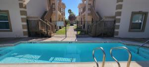a swimming pool in front of a building at EZ Walk to Beach Modern 2 bedroom Sleeps Many in South Padre Island