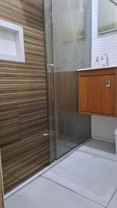 une douche avec une porte vitrée dans une salle de bain dans l'établissement Pousada Aconchegante COP30, à Belém
