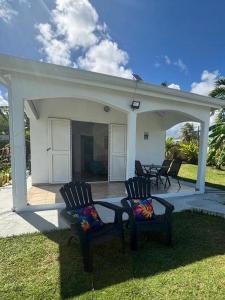Duas cadeiras sentadas num alpendre com um pátio em Mango-passion Le Domaine Mannou em Sainte-Rose mais 14 fotografias