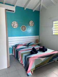 a bedroom with two beds with plates on the wall at Mango-passion Le Domaine Mannou in Sainte-Rose
