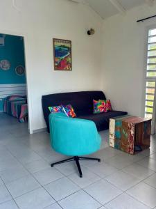 a living room with a blue couch and a table at Mango-passion Le Domaine Mannou in Sainte-Rose