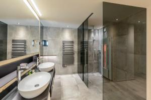 a bathroom with a sink and a shower at Sport- und Wellnesshotel Held 4 Sterne Superior in Fügen