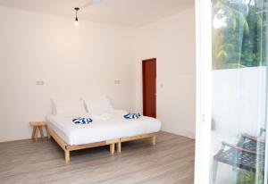 a bedroom with a bed with blue and white pillows at Shadow Isles Himandhoo in Himandhoo 