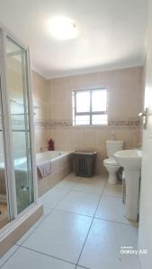 a bathroom with a toilet and a tub and a sink at 87 on Sunbird in Langebaan +11 photos