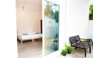 two views of a room with a bed and a window at Shadow Isles Himandhoo in Himandhoo  +28 photos