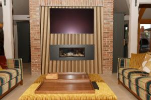 a living room with two couches and a fireplace at Dingle Dell in Great Driffield