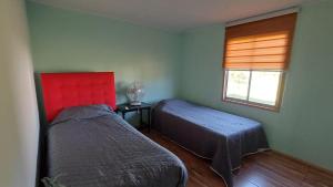 a bedroom with two beds and a window at Piscinas y cabañas san antonio in Los Ángeles