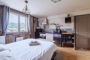 cocina con cama blanca en una habitación en Appartements vue Mont-Joly à 2 pas Tramway Mont-Blanc - Studio 1 pièce, en Saint-Gervais-les-Bains