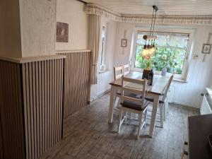 a dining room with a table and chairs and a window at Käpt'n Brandt in Osteel