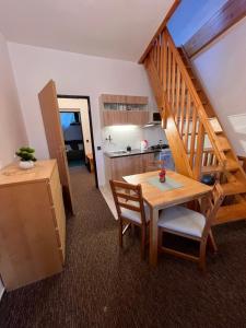 a kitchen and dining room with a table and a staircase at Penzion Mona Rooms & Apartments in Harrachov