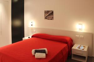 een slaapkamer met een rood bed en 2 handdoeken erop bij Reggionord in Reggio di Calabria