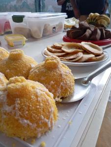 BarroquinhaにあるPousada Paraíso das Dunasのドーナツとパンケーキの皿が2枚置かれたテーブル