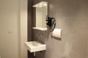 een badkamer met een wastafel en een spiegel aan de muur bij Reggionord in Reggio di Calabria