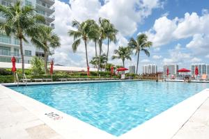 ein Swimmingpool in einem Resort mit Palmen in der Unterkunft Waterview Luxury 2-Bedroom Condo Sunny Isles Beach in Sunny Isles Beach