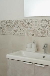 baño con lavabo blanco y pared blanca en Aetna apartment, en Nicolosi 13 fotos más