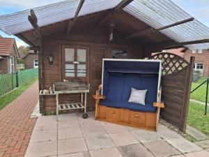 a wooden shed with a blue door and a table at Käpt'n Brandt in Osteel