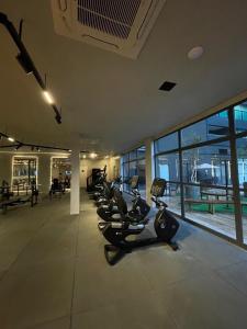 un gimnasio con una fila de cintas de correr y bicicletas estáticas en Art Stúdio Beira-Mar em Armação 123, en Salvador 57 fotos más
