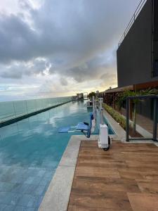 una piscina en la parte superior de un edificio junto al océano en Art Stúdio Beira-Mar em Armação 123, en Salvador