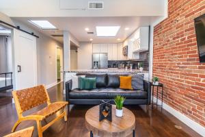 ein Wohnzimmer mit einer Couch und einer Ziegelwand in der Unterkunft Gaslamp 2BR Upscale Queen Beds with Smart TV in San Diego