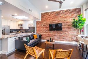 ein Wohnzimmer mit einer Couch und einer Ziegelwand in der Unterkunft Gaslamp 2BR Upscale Queen Beds with Smart TV in San Diego