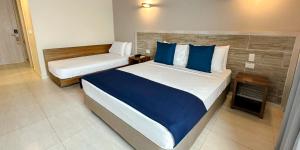a bedroom with two beds with blue pillows at Hotel Caribbean by On vacation in San Andrés