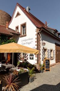 a white building with an umbrella in front of it at Landgasthaus Zum Engel in Neuleiningen