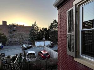 a red car parked in a parking lot next to a building at THE ADDAMS HOUSE - LANCASTER HISTORIC DISTRICT in Lancaster