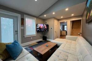 Una sala de estar con un sofá blanco y una mesa. en THE CONESTOGA HOUSE - THEATER & BUSINESS DISTRICT, en Lancaster