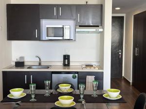 墨西哥城Bellísima Suite, 2 Camas Queen, Gym, en Interlomas的厨房配有带碗和玻璃杯的桌子